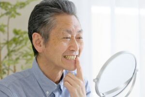 鏡で歯を見ている男性